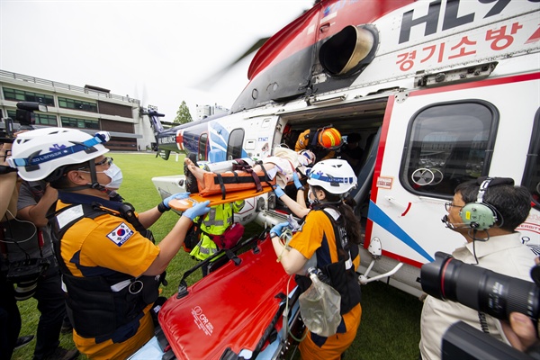 29일 오후 경기도청 잔디광장에서 열린 ‘응급의료전용 헬기 종합시뮬레이션 훈련’에서 119구급대가 닥터헬기로 환자 인계훈련을 하고 있다. 