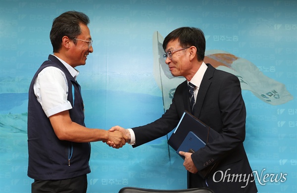 김상조 청와대 정책실장이 3일 오후 서울 중구 민주노총을 방문해 김명환 위원장과 악수하고 있다.