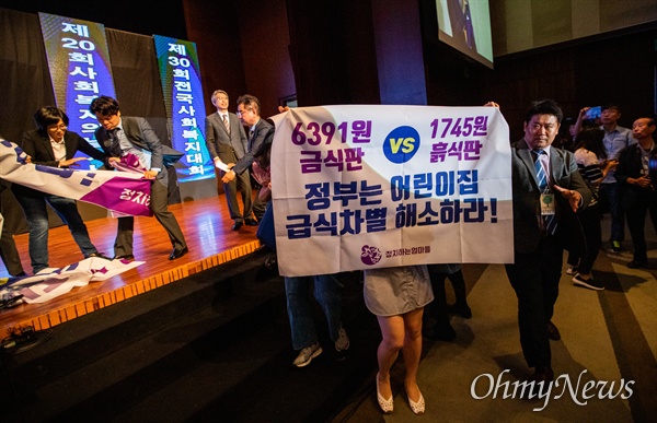 정치하는엄마들 회원들이 6일 오전 서울 서의도 63빌딩 컨벤션센터에서 열린 사회복지의날 기념식에서 기습시위를 펼치며 박능후 보건복지부장관을 향해 어린이집 급,간식비 인상을 요구하고 있다. 