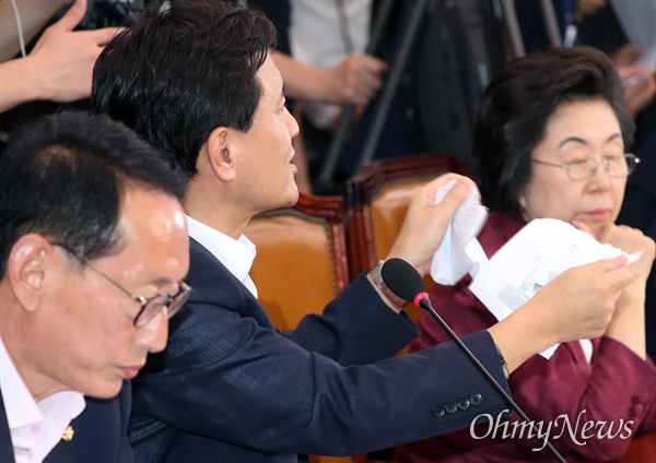 자유한국당 김진태 의원이 6일 국회 법제사법위원회에서 열린 조국 법무부 장관 후보자 인사청문회에서 조 후보자가 제출한 가족관계증명서를 찢고 있다. 