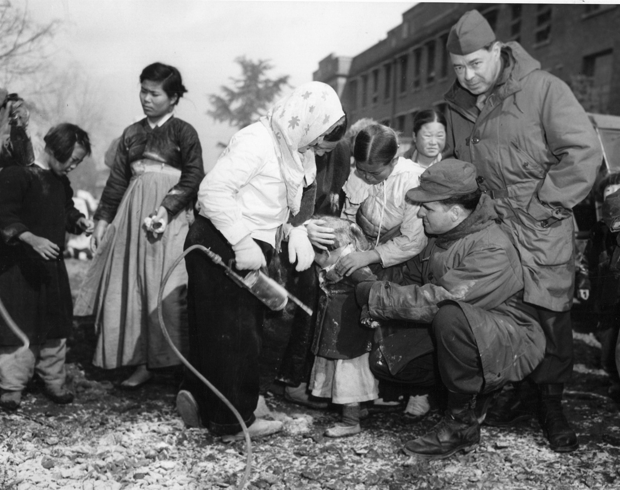 대구, 시민들이 어린이의 몸에 이를 박멸코자 미군들로부터 원조받은 DDT를 살포하고 있다(1951. 2. 16.).