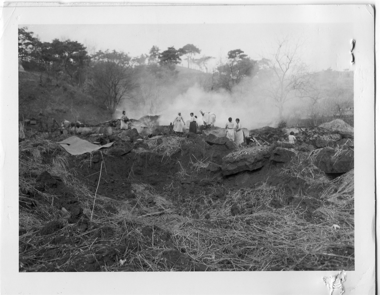 원주 근교 교항리 마을에 한 차례 미 전투기가 지나간 뒤 가재도구라도 건지려고 주민들이 접근하고 있다(1951. 2. 23.).