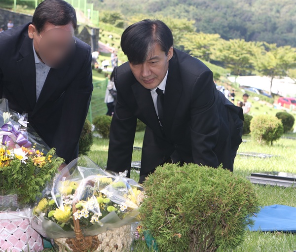  조국 법무부 장관이 14일 오전 부산 기장군 부산추모공원에 안장된 고 김홍영 전 검사 묘비를 만져보고 있다. 김 전 검사는 서울남부지검 형사부에 근무하던 2016년 5월 업무 스트레스와 직무 압박감을 토로하는 내용의 유서를 남기고 서른셋의 나이에 목숨을 끊었다. 2019.9.14