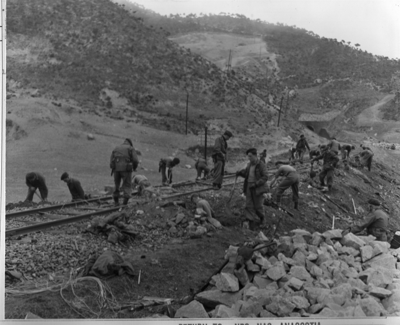 영국군 폭파조가 북한의 한 철길을 폭파하고자 폭약 매설작업을 하고 있다(1951. 5. 10.).  