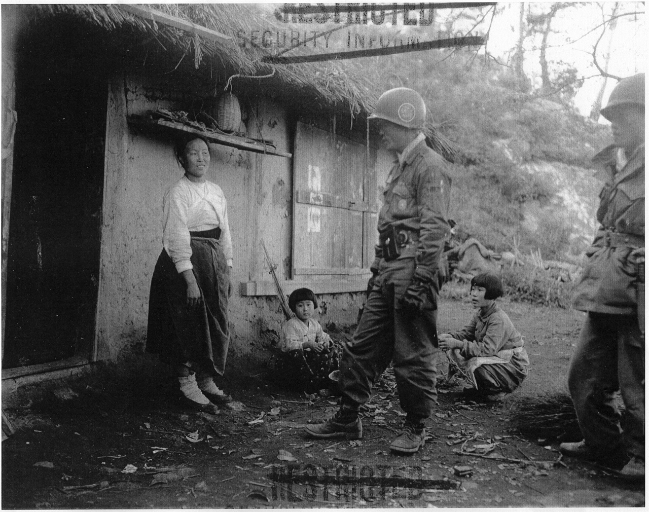 한국군 장교가 주민에게 적에 대한 정보를 수집하고 있다(1951. 10. 30.). 