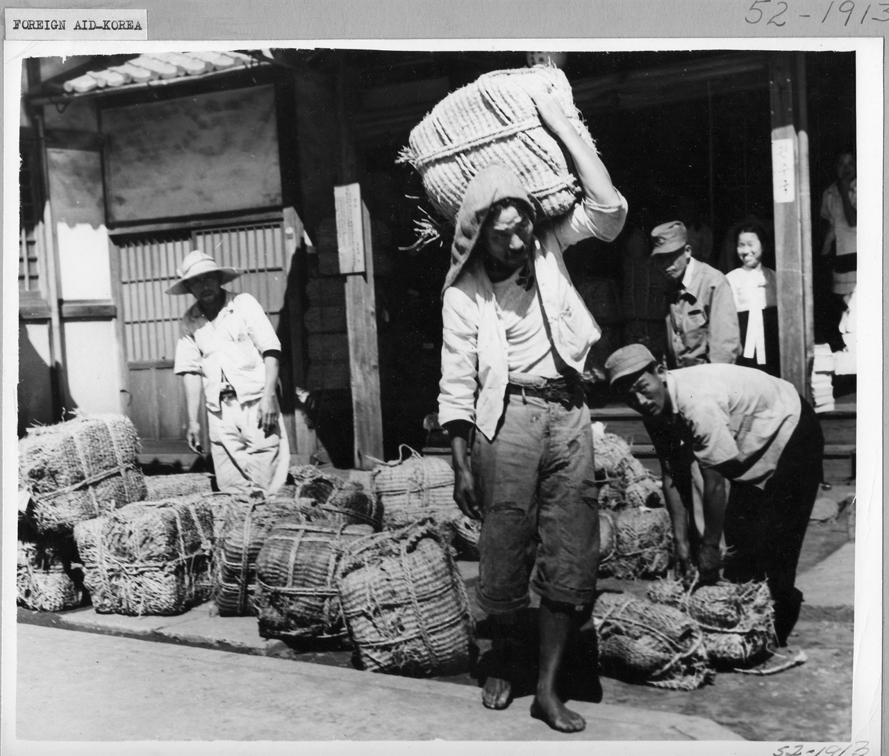 부산, 쌀가마니를 져다 나르는 부두노동자들(1951.).