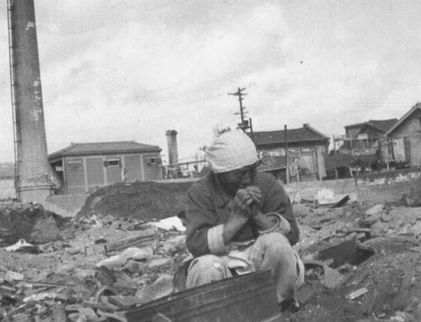 서울, 한 할머니가 폐허의 더미에서 쓸 만한 물건을 찾고 있다(1950. 11. 1.).