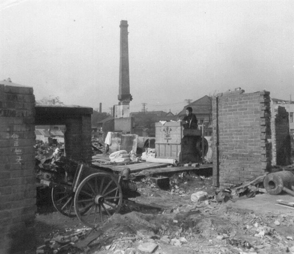 한 젊은이가 폐허가 된 집에 찾아와서 가재도구를 챙기고 있다(1950. 11. 1.).