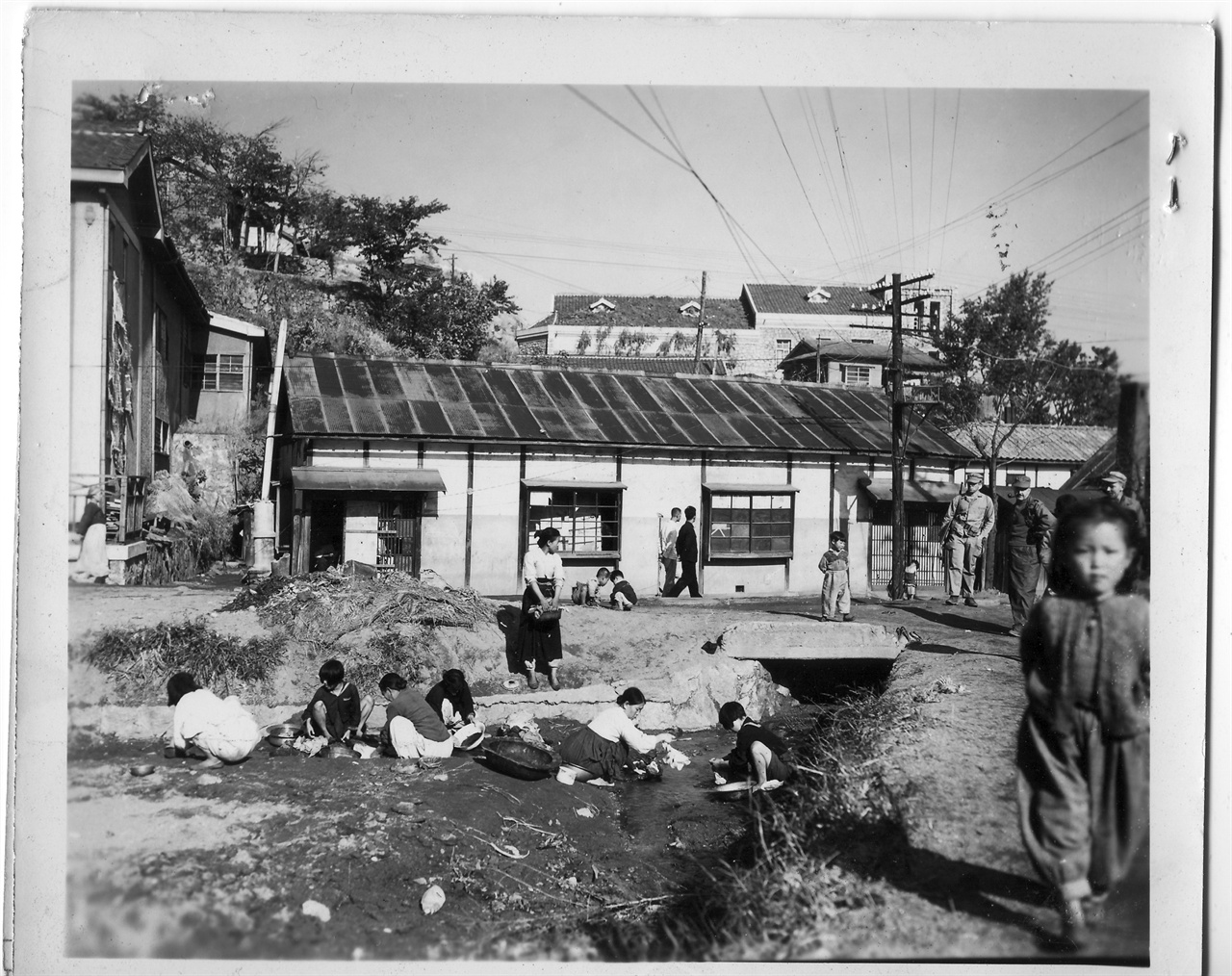 원산, 부녀자들이 동네 냇가에서 빨래를 하고 있다(1950. 11. 1.).