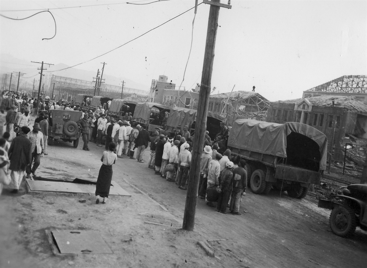 흥남, 미군부대에서 일할 노무자들을 트럭에 실어가고 있다(1950. 11. 8.).