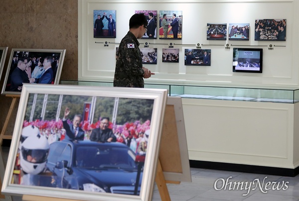 비무장지대(DMZ) 내 유해 발굴 작전에 참여한 군인이 19일 오전 서울 종로구 남북회담본부에서 열린 '9.19 평양공동선언 1주년 기념행사’에 참석해 문재인 대통령과 김정은 위원장의 사진을 관람하고 있다. 