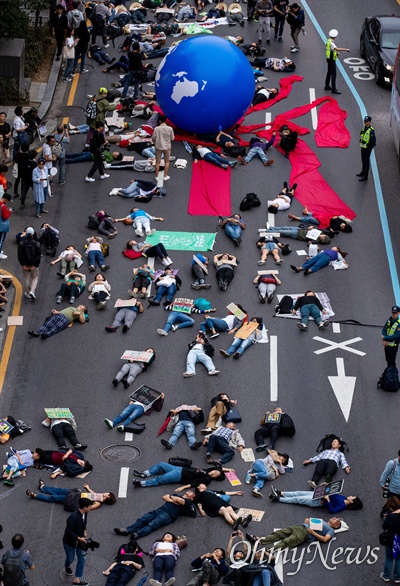 2019년 9월 21일 국제 기후 파업 주간을 맞아 서울 종각역 사거리에서 열린 9.21 기후위기 비상행동에서 참가자들이 '기후 위기가 다가오면 생존의 위협이 다가온다'는 의미의 퍼포먼스를 하고 있다.