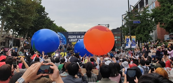 참가자들은 지구의  '기후위기'를 상징하는 퍼포먼스로 지구의를 둘리고 있다.