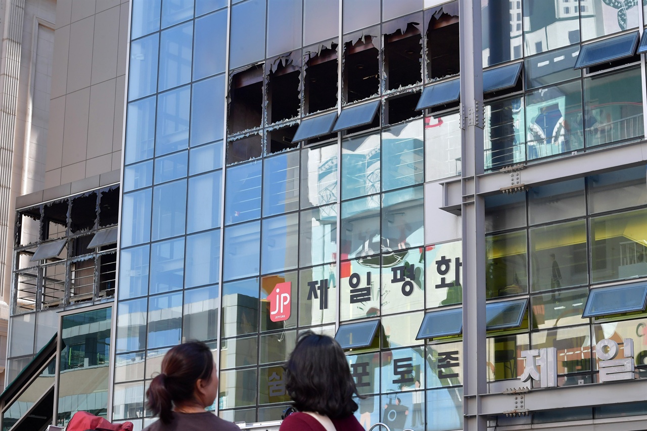 24일 오전 서울 중구 제일평화시장에서 국립과학수사대와 경찰 그리고 소방당국 관계자들이 지난 22일 발생한 제일평화시장의 화재원인을 찾기위해 현장 합동감식을 벌이고 있는 가운데 시민들이 불에 탄 건물앞을 지나가고 있다. 2019.09.24.