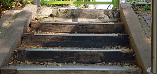 공원 어린이 놀이터에서 인근 초등학교로 연결돼 있는 계단이 검은색 기름이 함유된 방부목으로 설치돼 있다.