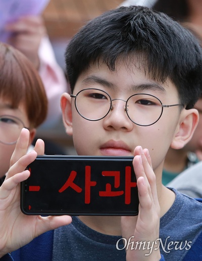 한 학생이 스마트폰에 '일본은 사과하라'는 문구를 표시하고 있다.