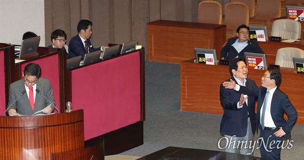 자유한국당 곽상도 의원이 26일 오후 국회 본회의장에서 열린 정치 분야 대정부질문에서 조국 법무부 장관을 '피의자 조국'이라고 부르자 더불어민주당 이원욱 원내수석부대표가 항의하고 있다. 이를 자유한국당 정양석 원내수석부대표가 말리고 있다. 