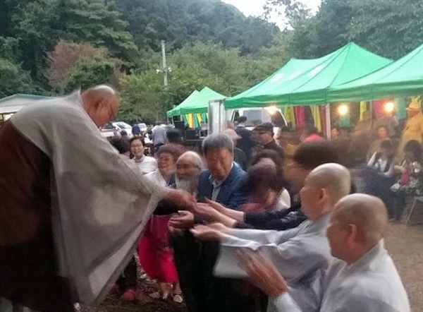  지승 스님이 참석자들에게 쑥과 마늘을 나눠 주고 있다.