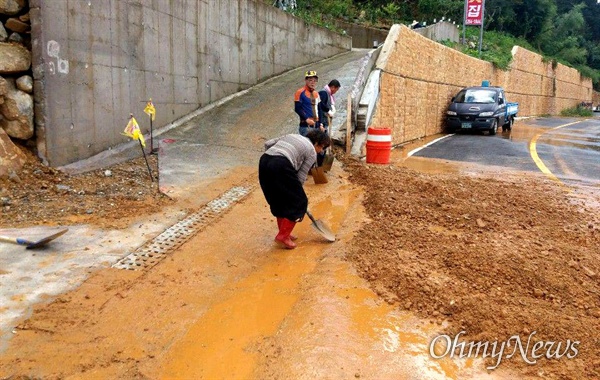 태풍 '미탁'으로 폭우가 내리면서 창원의 한 도로에 토사가 유출되어 복구작업이 진행되고 있다.