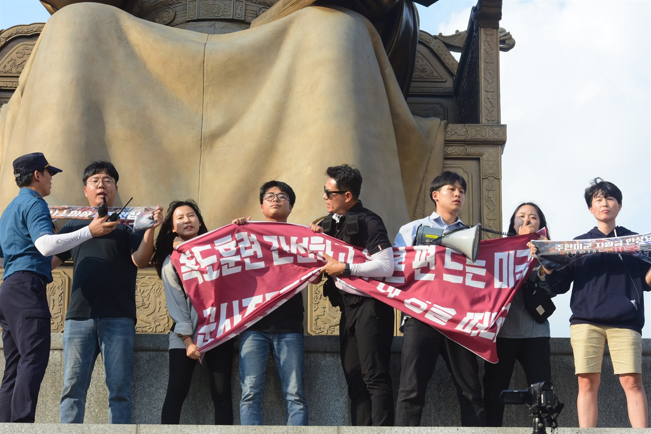  한국대학생진보연합 소속 대학생 6명이 4일 오후 서울 세종로 광화문광장내 세종대왕 동상에 올라가 ‘한일 군사정보보호협정(GSOMIA·지소미아)’ 파기를 방해하는 미국을 규탄하는 기습시위를 벌고 있는 가운데 경찰에 시위학생들이 펼쳐든 현수막을 강제로 빼앗고 있다. 2019.10.04