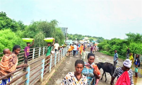 수단 남부 갈라밧 마을과 에티오피아 북부 메테마 마을을 잇는 국경의 다리를 건너는 사람들