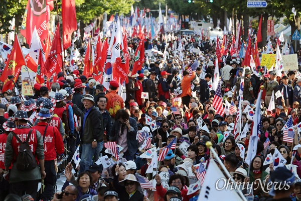지난해 10월 서울 종로구 광화문 광장 일대에서 열린 '문재인 하야 범국민 2차 투쟁대회' 참가자들이 청와대 앞까지 행진해 태극기와 성조기를 흔들며 구호를 외치고 있다. 