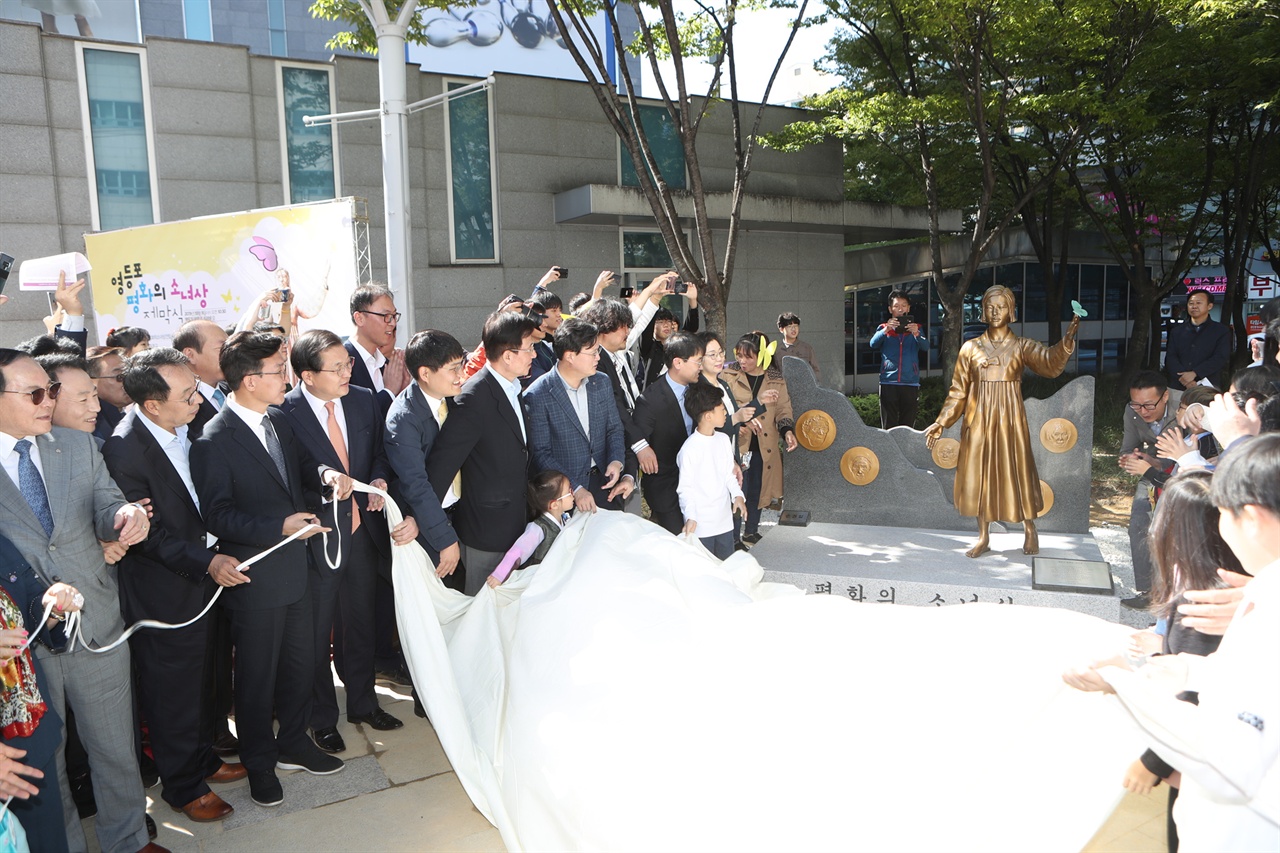 9일 서울 영등포구 타임스퀘어 광장에서 열린 '평화의 소녀상'이 제막식에서 참석자들이 소녀상을 공개하고 있다.