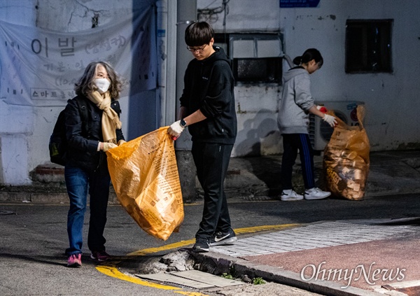  12일 밤, 서울 서초역 인근 골목길에서 '제9차 사법적폐청산을 위한 검찰개혁 촛불문화제'에 참석하지 못한  엄마와 자녀들이 자원봉사활동으로 참가자들이 버린 쓰레기 뿐만 아니라 골목의 담배꽁초 등 2시간 가량 청소를 하고 있다.