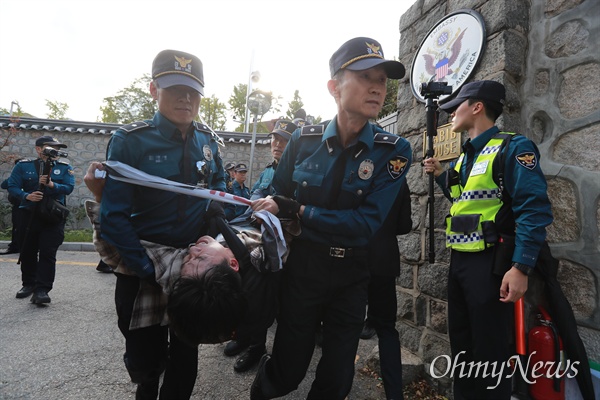 한국대학생진보연합 소속 대학생들이 과도한 주한미군 방위금 분담금(6조) 요구에 항의하며 18일 오후 서울 중구 덕수궁 뒤편 미대사관저 담장에 사다리를 놓고 넘어들어가는 기습 시위를 벌였다. 사다리를 이용해 미대사관저에 들어갔던 대학생들이 경찰에 의해 끌려나오고 있다.