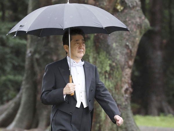 아베 신조(安倍晋三) 일본 총리가 지난 22일 오전 나루히토(德仁) 일왕의 즉위식이 열리는 도쿄 왕궁 규추산덴(宮中三殿) 중 가시코도코로(賢所)로 우산을 받쳐 들고 걸어가고 있다. 