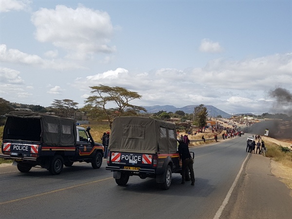 케냐에서 탄자니아 국경으로 넘어가는 언덕에서 폭동이 일어나 경찰들이 버스와 화물차를 통제하고 있는 모습. 