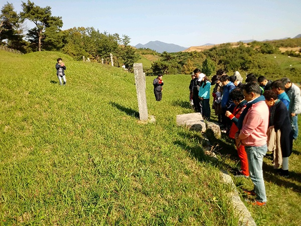 역사진흥원 주최 역사 탐방 참가자들이 홍의장군 묘소를 참배하고 있다.