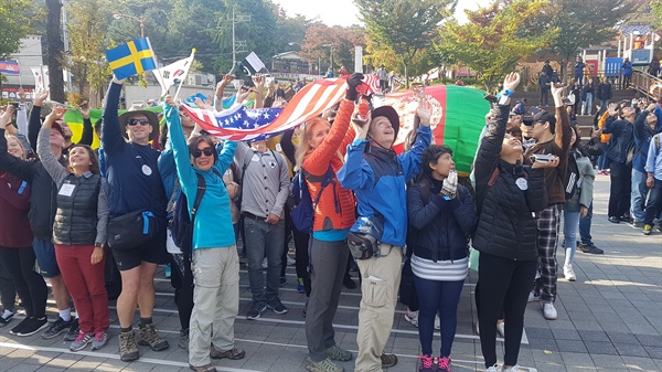 10월 26일 오전 '서울둘레길, 세계인이 걷는다' 페스티벌 참가자들이 우이동 만남의광장에서 출발하기에 앞서 각국의 깃발을 흔들고 있다.
