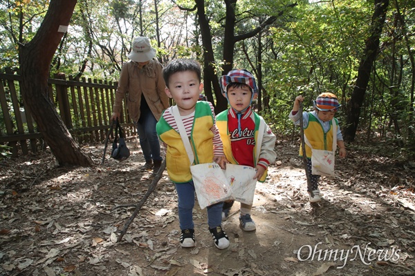 예쁜아이어린이집 아이들이 25일 오전 서울 동작구 와우산에서 나뭇가지를 지팡이 삼아 산책로를 걷고 있다.