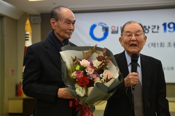  김자동 대한민국임시정부기념사업회장(오른쪽)이 제1회 민족일보 조용수 언론상을 수상했다. 이날 시상식에는 민족일보 조용수 사장의 동생 조용준 민족일보기념사업회 고문(왼쪽)이 참석해 김자동 회장에게 꽃다발을 전달하며 축하를 했다.