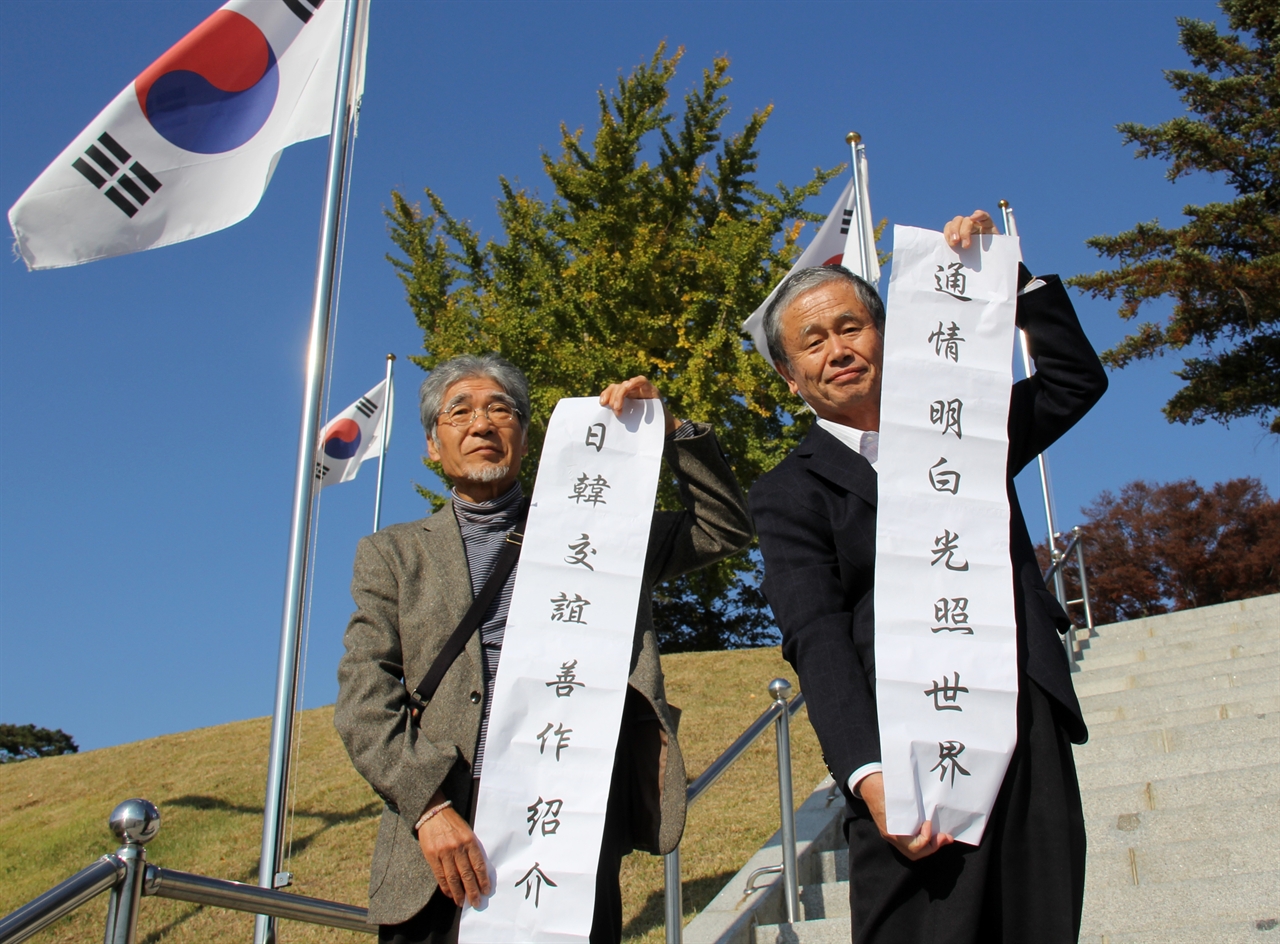  일본 시민단체 대표단은 경색된 한일관계를 푸는해법으로 안중근 의사가 쓴 글귀를 해법으로 제시했다. 구마모토 시민단체 대표단인 우치다 케이스케( 田 敬介, 구마모토 한일교류 네트워크 대표,왼쪽)씨와 다나카 노부유키(田中 信幸, 평화헌법을 살리는 구마모토 현민의회 사무국 차장)씨가 충남 예산 덕산에 있는 윤봉길 기념관 앞에서 안중근 의사가 일본 통역관에게 써준 '日韓交誼善作紹介'(일한교의선작소개, 한일 우호를 위해 서로 잘 알아 가야 한다,왼쪽)와 '通情明白光照世界'(통정명백광조세계,정이 통하는 친분이 생길 때 빛은 세상을 비춘다)라는 유묵을 들고 있다.