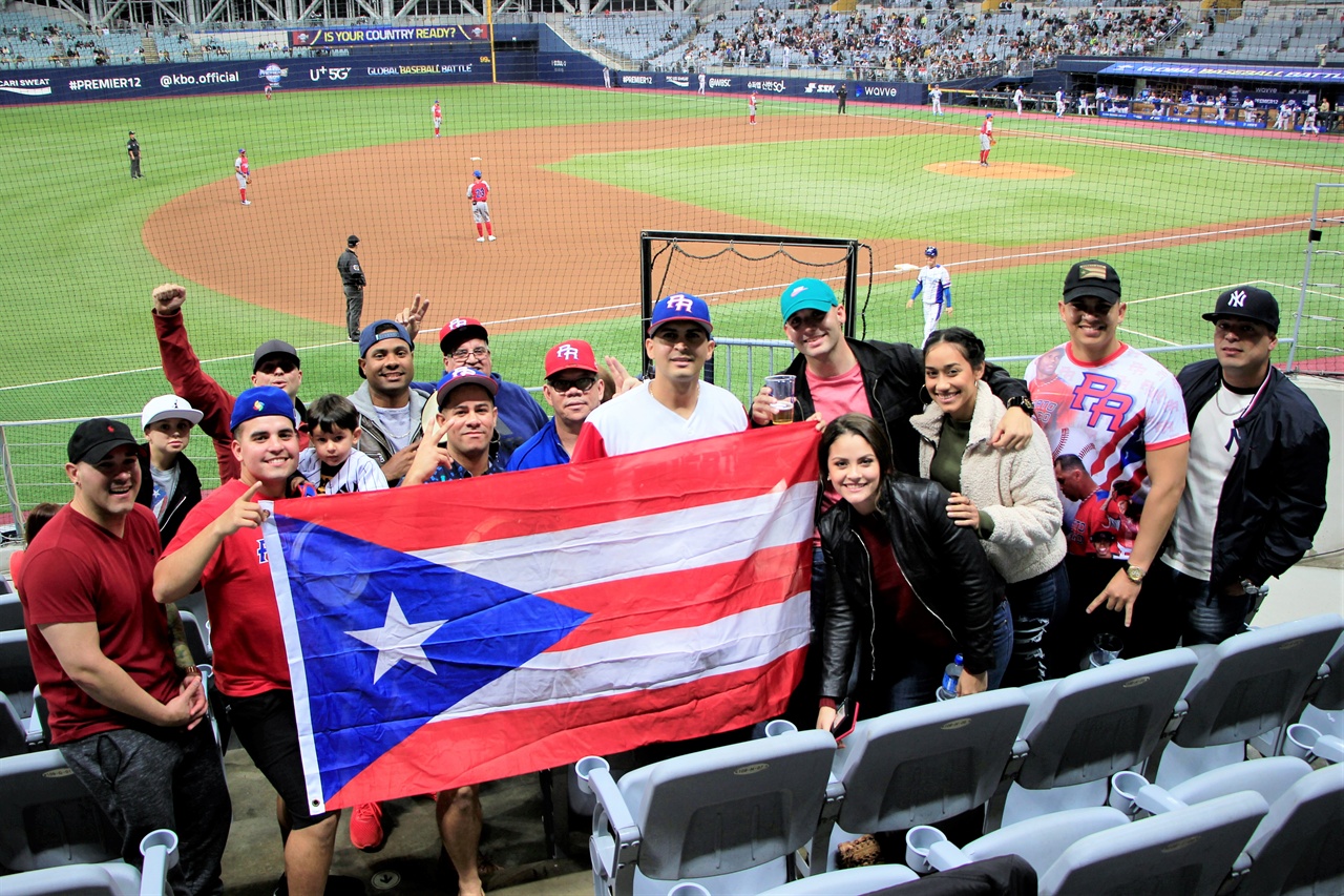  푸에르토리코에서 온 응원단이 국기를 들고 포즈를 취하고 있다.