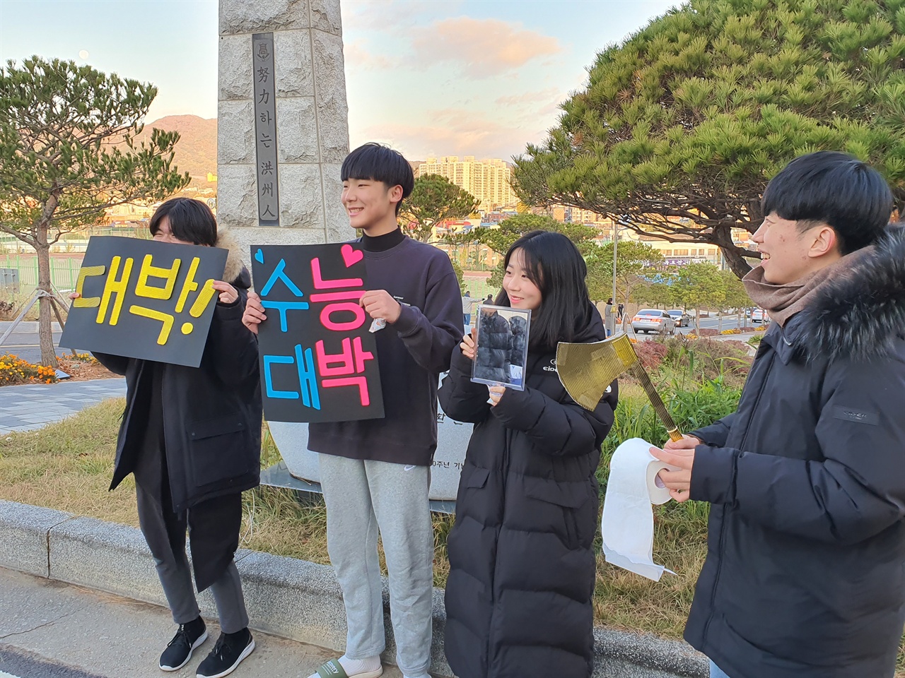  후배들은 응원 손팻말과 잘찍고 잘 풀고 잘 보라는 의미로 손도끼, 휴지, 거울을 들고 응원하고 있다