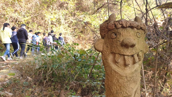 도깨비마을로 가는 숲길 산책로. 숲 군데군데에 뱅싯이 웃음 짓게 하는 조깨비 조각상이 세워져 있다.