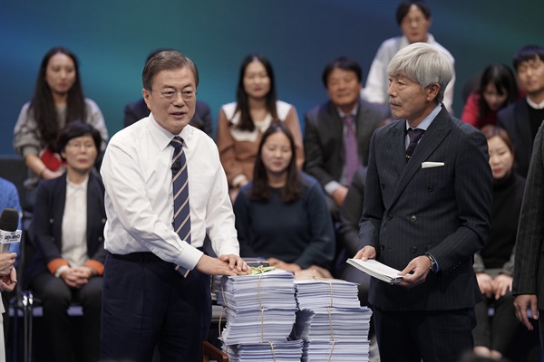 문재인 대통령이 19일 오후 서울 상암동 MBC에서 '국민이 묻는다, 2019 국민과의 대화' 종료 후 시간 관계상 받지 못한 질문지를 전달받고 있다.