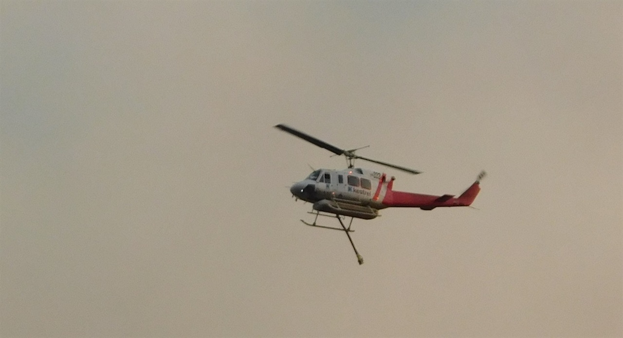 수시로 지붕 위를 오가며 화재 진압에 안간힘을 쏟는 헬리콥터