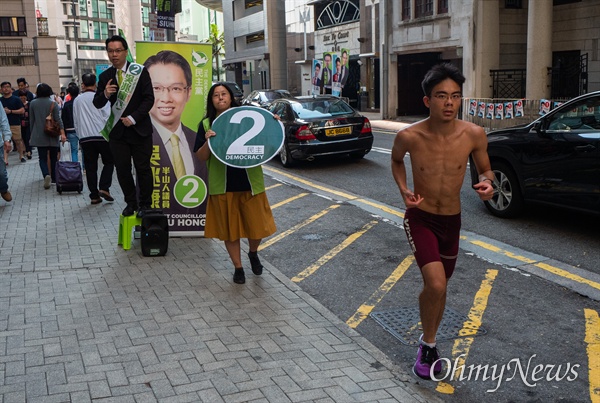 구의원 선거가 치러지는 24일 오전 홍콩 미드레벨 레이몬드 대학에 차려진 투표소 인근에서 민주당 후보가 유권자들을 향해 유세를 하고 있다.

