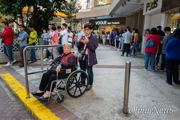 구의원 선거가 치러지는 24일 오전 홍콩 커즈웨이베이 커뮤니티센터에서 시민들이 투표를 하기 위해 길게 줄을 서 있다. 투표를 하기 위해 수백명이 줄을 서 한 시간 이상을 기다려야 하는 상황이 발생했다.