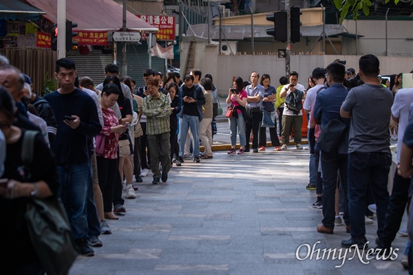 구의원 선거가 치러지는 24일 오전 홍콩 커즈웨이베이 커뮤니티센터에서 시민들이 투표를 하기 위해 길게 줄을 서 있다. 투표를 하기 위해 수백명이 줄을 서 한 시간 이상을 기다려야 하는 상황이 발생했다.