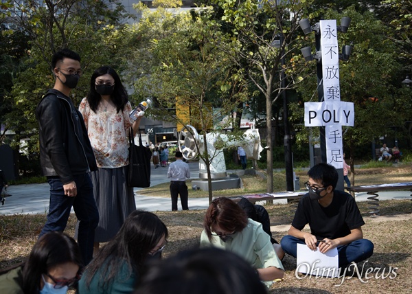 홍콩 구의원 선거가 범야권의 압승 결과로 나온 25일 오후 홍콩 퀀통 한 공원에서 홍콩이공대 내 빠져나오지 못하고 있는 시위대를 위해 지지피켓을 만들고 있다. 