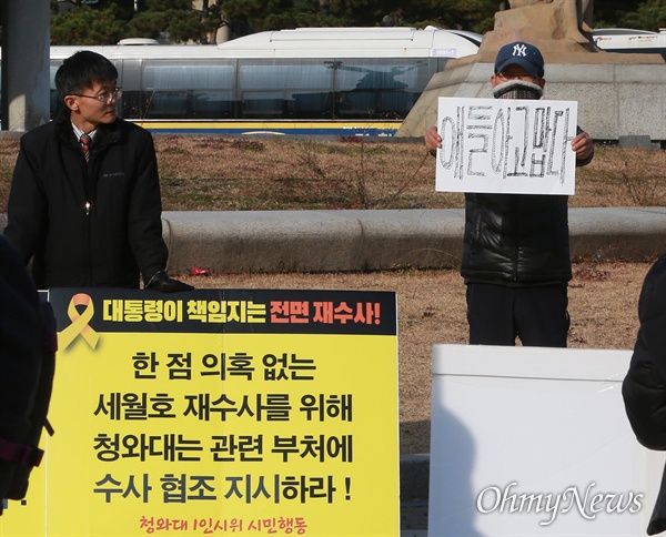 27일 오후 청와대 분수대광장에서 세월호참사 성역없는 철저한 재수사를 촉구하며 1인 시위를 벌이는 시민옆에서 '공수처 반대' 시위를 하던 한 보수인사가 '공수처 반대'가 적힌 피켓 뒤에 '얘들아 고맙다"를 적어 들고 있다. 지난 2017년 당시 민주당 대선경선에 나선 문재인 후보는 진도 팽목항 세월호참사 분향소 방명록에 “얘들아, 너희들이 촛불광장의 별빛이었다. 너희들의 혼이 1000만 촛불이 되었다. 미안하다. 고맙다”고 적었다. 논란이 일자 경선캠프 박광온 수석대변인은 “미안한 것은 이 나라의 어른으로서 살려내지 못한 때문이고, 고마운 것은 그들의 가슴 아픈 죽음이 우리 사회가 이윤보다 사람이 먼저라는 것을 새로 깨닫고 거듭 태어나는 계기를 만들었기 때문”이라고 설명했다.