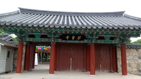 아담한 기와지붕 아래에 분황사 현판과 붉은 칠을 한 세 개의 문이 달려 있다.