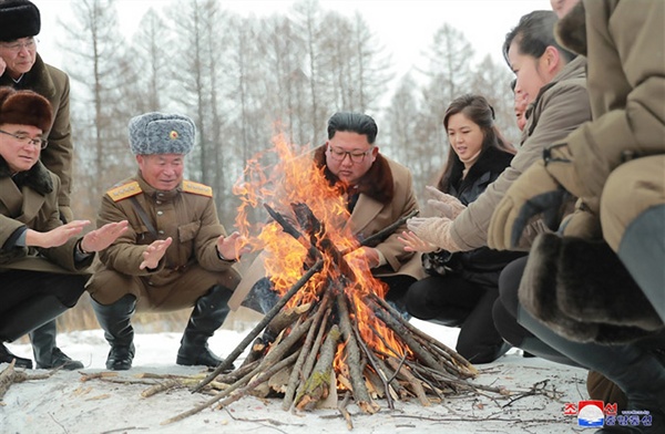 김정은 북한 국무위원장이 군 간부들과 함께 군마를 타고 백두산에 올랐다고 조선중앙통신이 4일 보도했다. 사진은 김 위원장이 간부들과 모닥불을 쬐고 있는 모습으로, 김 위원장 오른쪽에 부인 리설주 여사도 자리하고 있다. 