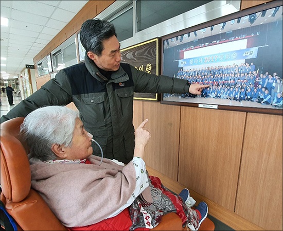 오희옥 지사가 나온 사진 앞에서 오희옥 지사와 아드님(김흥태 선생)이 사진을 보고 있다.