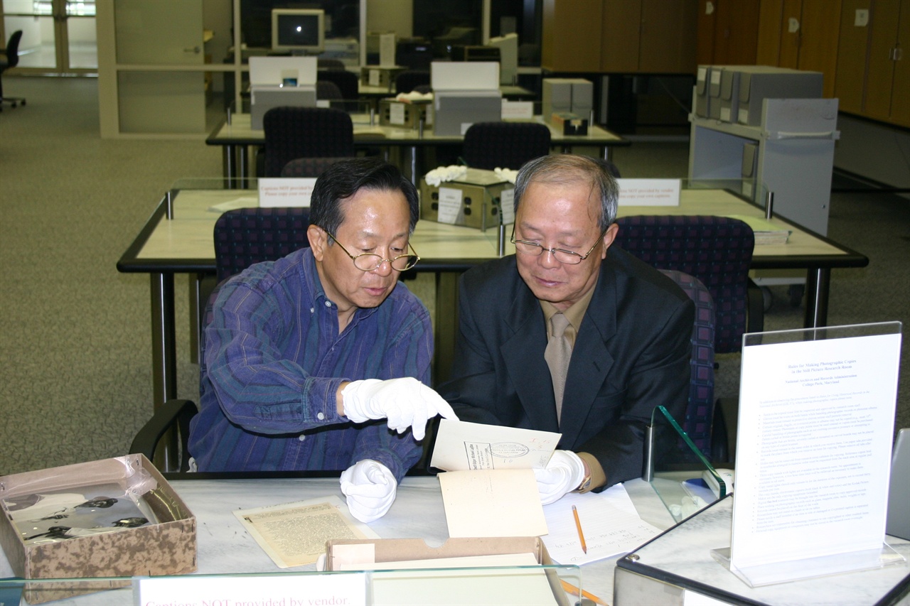 박유종 선생(왼쪽)이 영문사진설명을 기자에게 번역해 주고 있다(NARA 5층 사진자료실).